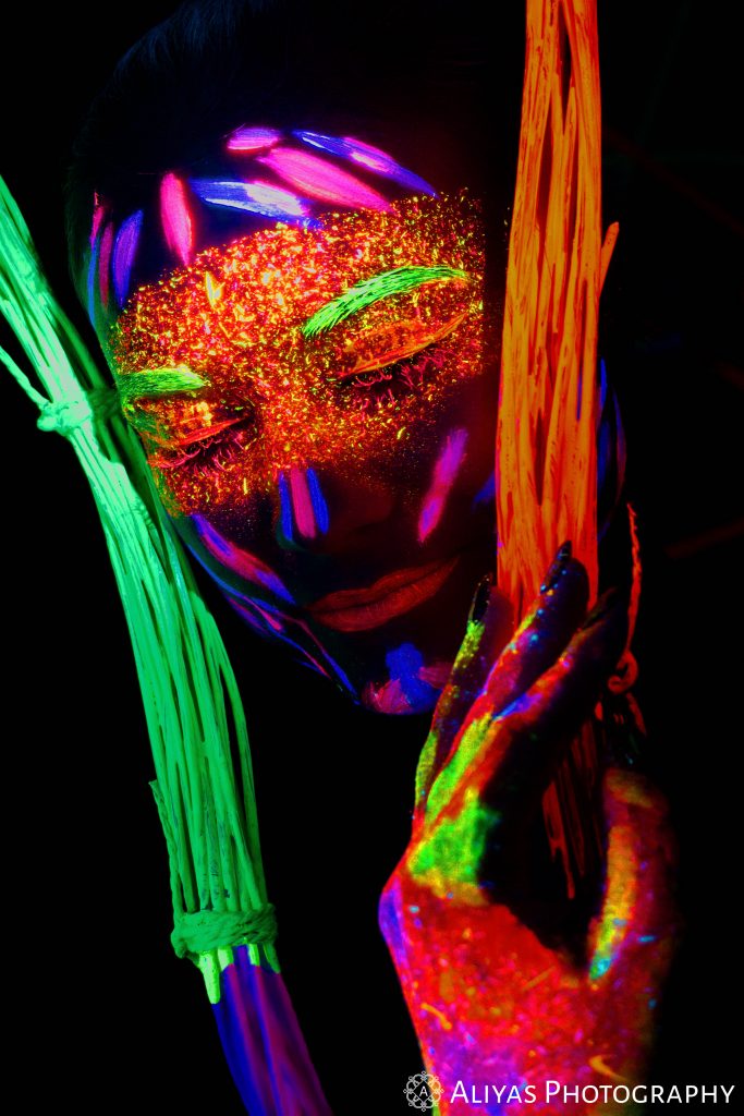 On the picture, you can see a model who has been photographed with blacklight. Her face is painted with special blacklight face paint colors which means that the colors glow in the dark in many different colors.