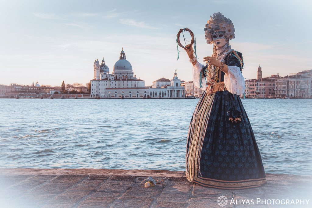 Woman wearing a Venetian costume and mask in the Carnival of Venice.